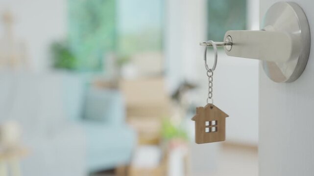 Moving house, relocation. The key was inserted into the door of the new house, inside the room was a cardboard box containing personal belongings and furniture. move in the apartment or condominium