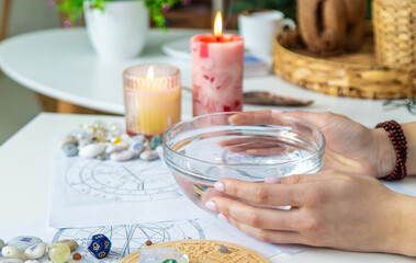 Ceromancy wax divination ritual with astrological charts, crystals, and runes on a table