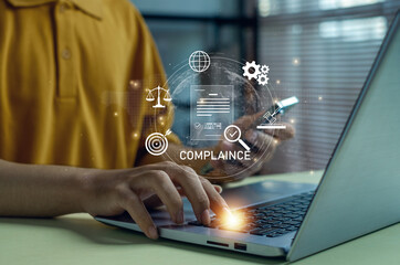 Business compliance officer using laptop and smartphone with digital audit, data security, regulation and quality control icons, representing modern corporate governance technology.