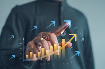 Business performance growth concept with hand touching rising bar chart and upward arrows on virtual screen, representing data analytics, financial success, digital strategy and revenue increase.