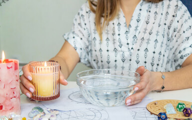Ceromancy wax divination ritual with astrological charts, crystals, and runes on a table