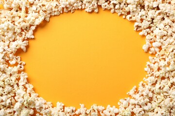 Obraz premium Tasty popcorn on orange background, flat lay. Space for text
