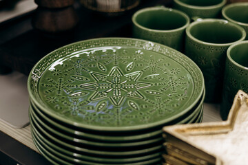 Green plates with decorative patterns arranged for Christmas holiday.