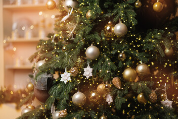 Festive christmas tree with gold and silver ornaments and snowflakes, sunlight