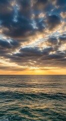 Obraz premium Dramatic Sunset Sky with Dark Clouds Over a Calm Ocean.