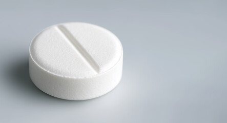 Macro shot of a white medical tablet on a clean clinical surface. Pharmaceutical image ideal for healthcare, medicine, and professional medical presentations.