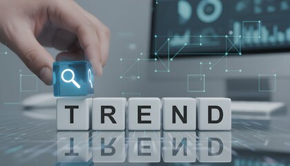 A hand placing a magnifying glass icon cube on "TREND" blocks, symbolizing trend analysis and search in a digital business context.