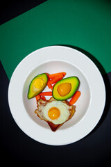 fried eggs with avocado and vegetables