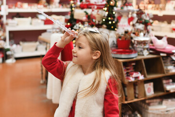 A girl chooses a toy icicle for the Christmas tree