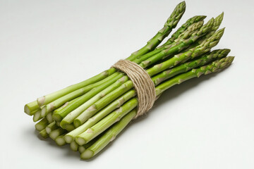 Fresh green asparagus spears tied with twine on a white background. vibrant image showcases a bundle of fresh asparagus, perfect for culinary and health-related content.