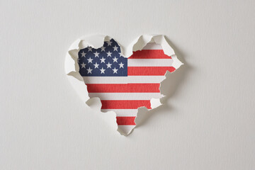 American flag heart shape torn from paper on a white background. the United States flag in a heart shape, perfect for patriotic themes and designs.