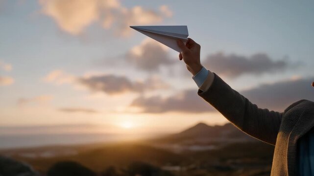 Hands releasing a paper airplane into the sky during golden hour &mdash; concept of freedom, aspiration, playful creativity, and symbolic lifestyle photography. cinematic color correction, natural uneven