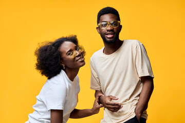 Happy couple wearing stylish glasses, bright yellow background, showcasing joy and connection, perfect for lifestyle and fashion concepts