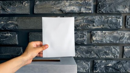 Individuals engage in the voting process, submitting their ballots into a secure box in a polling location, ensuring their voices are heard