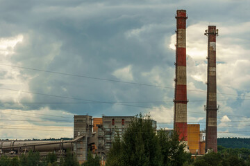 A large industrial plant. The high pipes of the factory emit harmful substances into the atmosphere. Environmental pollution.