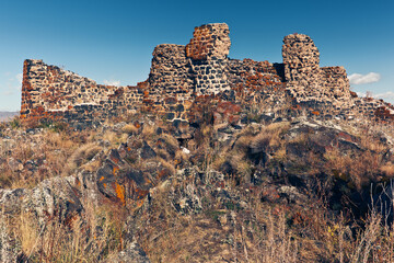 View of ruins of medieval fortress Berdkunk located on the rocky shore of Lake Sevan. Berdkunk, Gegharkunik Province, Armenia