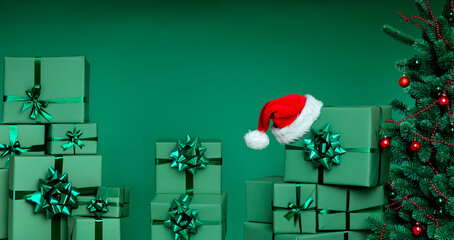 Green Christmas Gift Boxes and Santa Hat With Decorated Tree, Minimal Festive Holiday Background in...