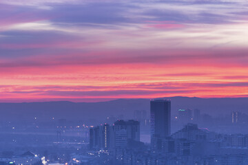 Fototapeta premium A colorful sunset illuminates the urban skyline with stunning hues, captivating beauty, Krasnoyarsk evening city at sunset panorama.