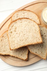 Bread slices with butter on white wooden table, top view