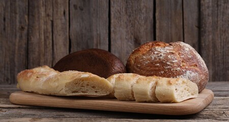 Different types of bread on wooden table, closeup