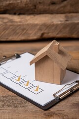 Wooden toy house on checklist clipboard for real estate or home inspection concept