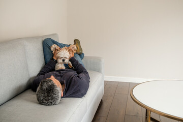 A man and his dog are laying on a couch