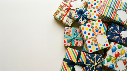 Birthday presents for a little boy or girl in wrapping paper and ribbons of various designs and colors. Animals, stripes and balloons. Ample copy space. Name tags.
