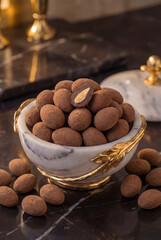 chocolate covered almonds presented in a stunning marble bowl for a gourmet treat