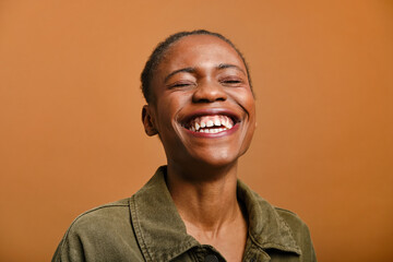 close up shot of Young black woman laughing with eyes closed in studio