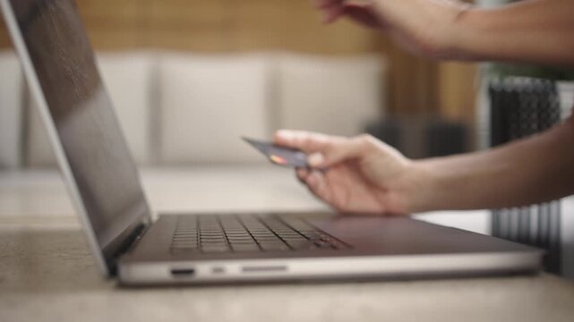 Close-up of female hands entering card details on a laptop, followed by cash banknotes appearing. Concept of online payments, e-commerce, digital transactions and credit.