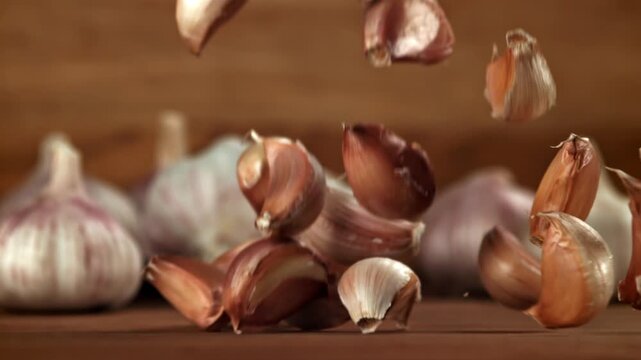 Garlic falls on a wooden table. Filmed on a high-speed camera at 1000 fps. High quality FullHD footage