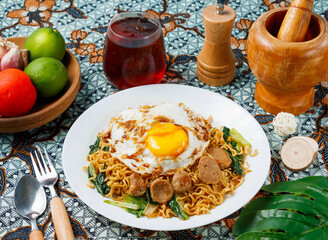 Delicious Indonesian Mie Goreng noodles topped with sunny side up egg and meatballs ready to eat