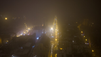 Widok z drona na nocne Stare Miasto w Toruniu, spowite delikatną mgłą. Podświetlone budynki i zabytkowa architektura lśnią w mgiełce, tworząc tajemniczy i nastrojowy miejski pejzaż. © Elżbieta Kaps