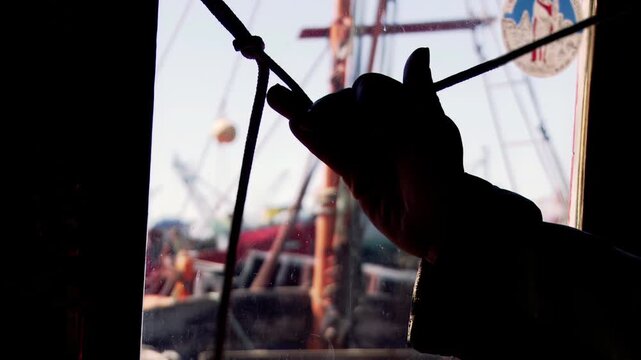 Fisherman Pulling Horn Rope Inside Old Artisanal Fishing Boat, Mar del Plata Harbor, Argentina - 4K