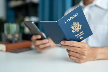 Hand Man Online booking and buying plane tickets using laptop phone and credit card Planning trip travel vacation with passport and ticket.