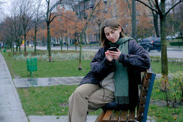 Fototapeta premium Woman checking phone on bench