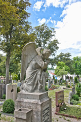 Großer Engel kniet betend auf einem Grabstein auf dem Friedhof in Kaufbeuren © Blende8