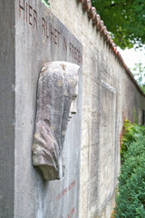Hier ruhet in Frieden, Mariendarstellung des Kopfes an einer Wand auf  dem Katholischen Friedhof in Kempten Allgäu © Blende8