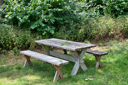 Ein Tisch und zwei B&auml;nke zum Verweilen in einem Park in Bayern 