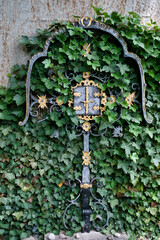 Reich verziertes Eisenkreuz mit einem kleinen Kasten zum öffnen auf  dem Katholischen Friedhof in Kempten Allgäu © Blende8