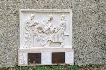 Bibeldarstellung wie die Jünger den toten Jesus tragen auf einem Grabstein auf  dem Katholischen Friedhof in Kempten Allgäu
