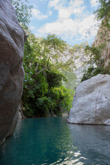 Stunning narrow Goynuk gorge with majesty of cliffs and turquoise waters. Dramatic rock formation towering over Goynuk canyon waters, Turkey.