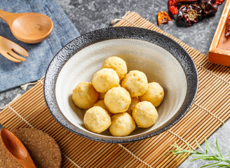 Deliciously golden fish balls served hot in a rustic ceramic bowl ready for savory Asian cuisine enjoyment