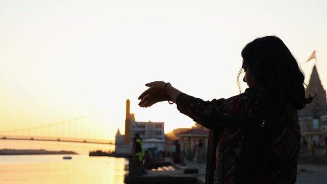 spiritual moment of woman pouring sacred water to holy god from hands in serene backlight