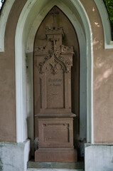 Familiengrabstätte in einer großen Wand mit schönem Stein auf einem Waldfriedhof in Memmingen © Blende8