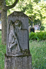 sehr alter Grabstein mit einem Posaunenengel auf einem Waldfriedhof in Memmingen © Blende8