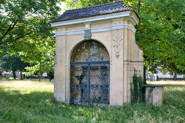 schönes altes Mausoleum mit einer reich verzierten Eisentüre  auf einem Waldfriedhof in Memmingen © Blende8