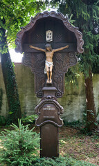 sehr schönes altes Holzkreuz mit viel Verzierung und dem Jesus am Kreuz auf dem Waldfriedhof in Memmingen © Blende8