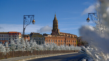 Montauban Scenic urban landscape with historic church tower and winter decorations in downtown setting against clear blue sky during holiday season