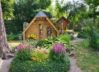Viele Blumen wie in einem Garten schmücken dieses Familiengrab mit einem schönen Holzkreuz auf dem Waldfriedhof in Memmingen © Blende8